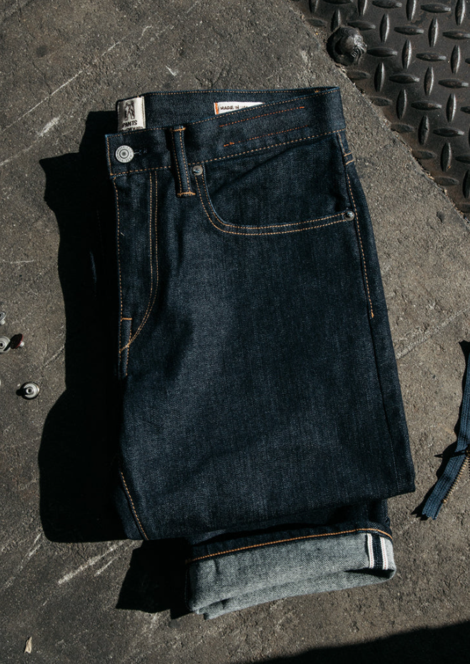 Folded dark blue jeans on a textured surface