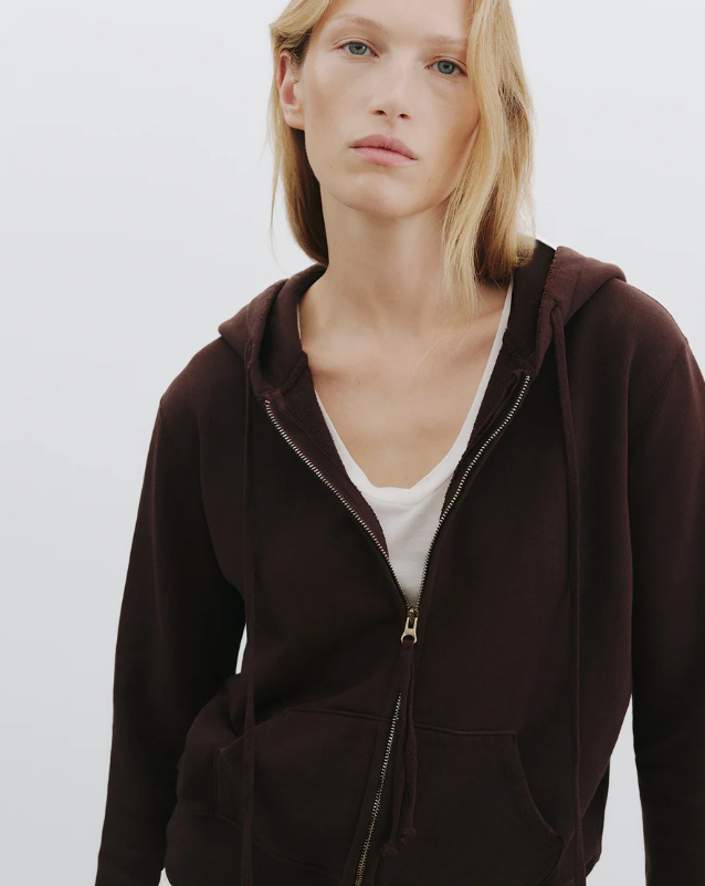 Person wearing a brown hoodie on a plain background