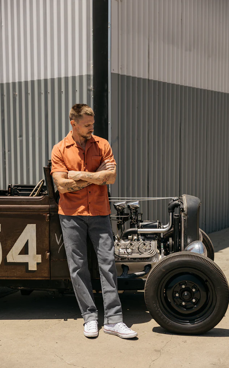 Man standing next to a vintage car with a number 4 on a metallic background