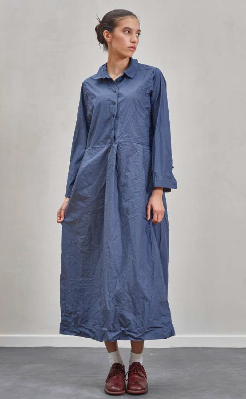 Woman wearing a long blue dress against a plain background