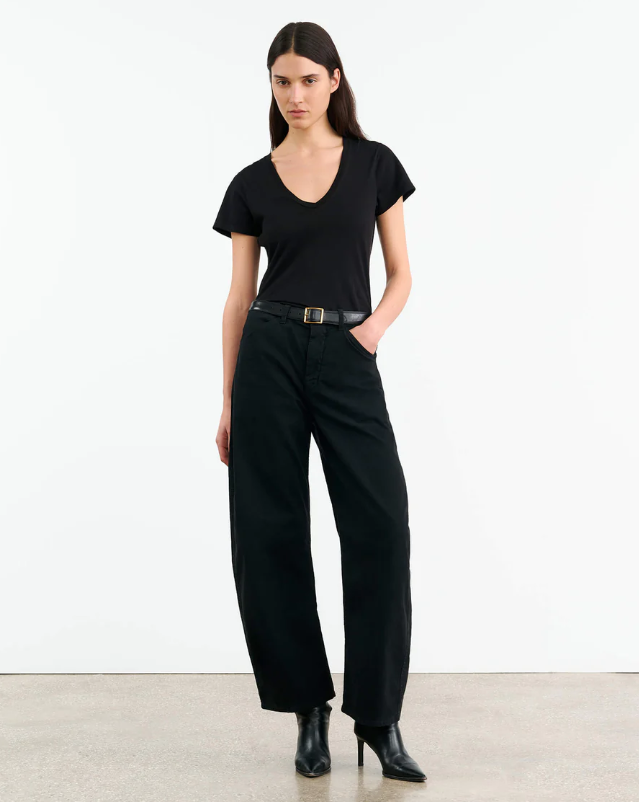 Woman wearing a black outfit with a plain white background