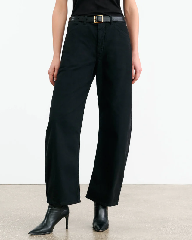 Person wearing black wide-leg pants on a plain background