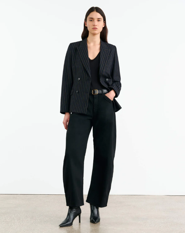 Woman wearing a black pinstripe suit with a white background