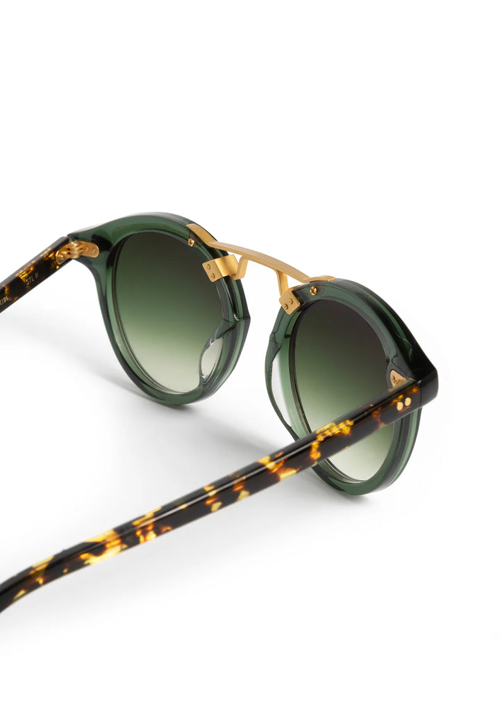 Sunglasses with green lenses and tortoiseshell frame on a white background