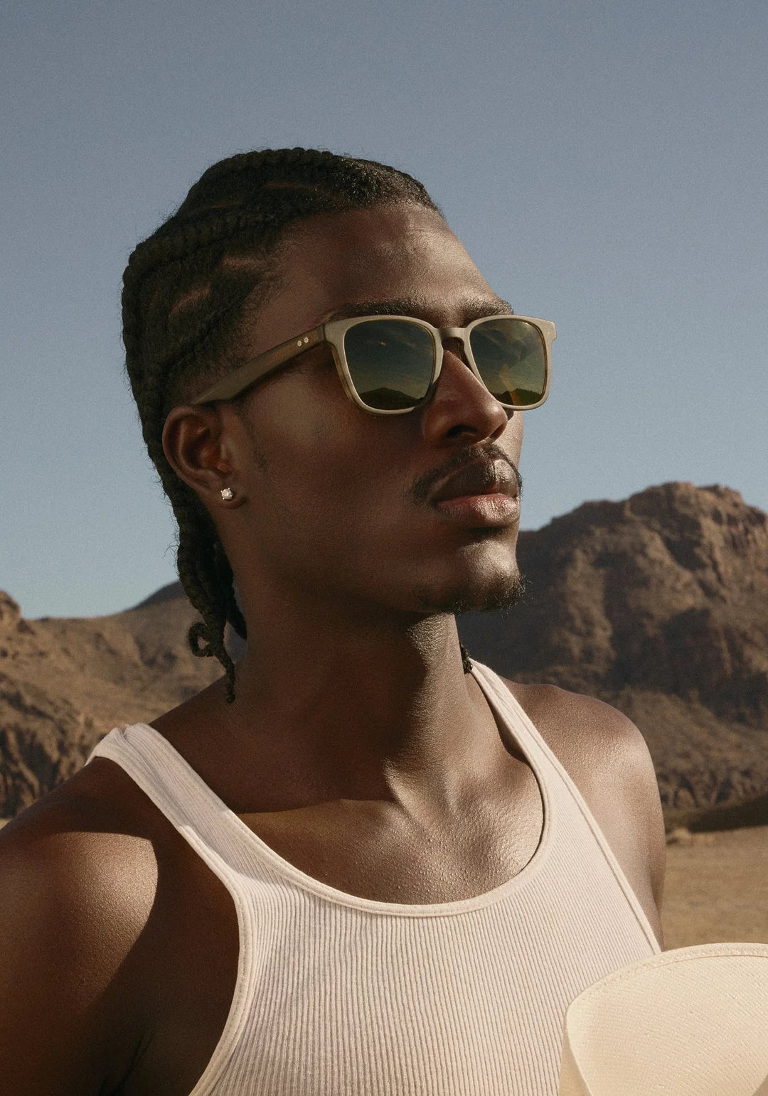 Man wearing sunglasses with mountains in the background