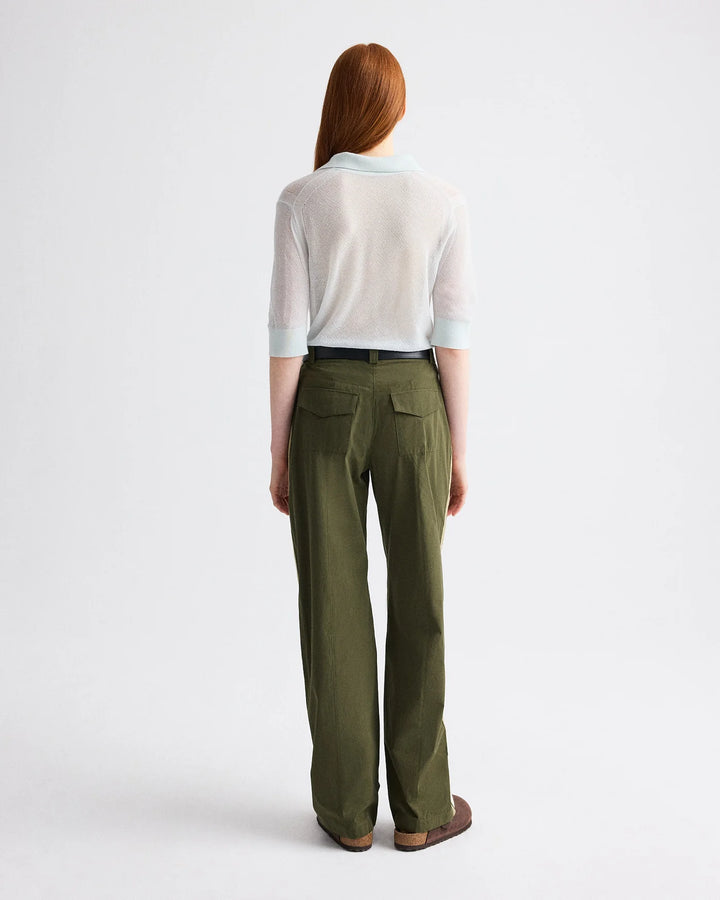 Person wearing a white shirt and green pants on a white background