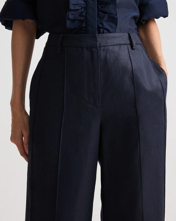 Navy blue pants worn by a person on a light gray background