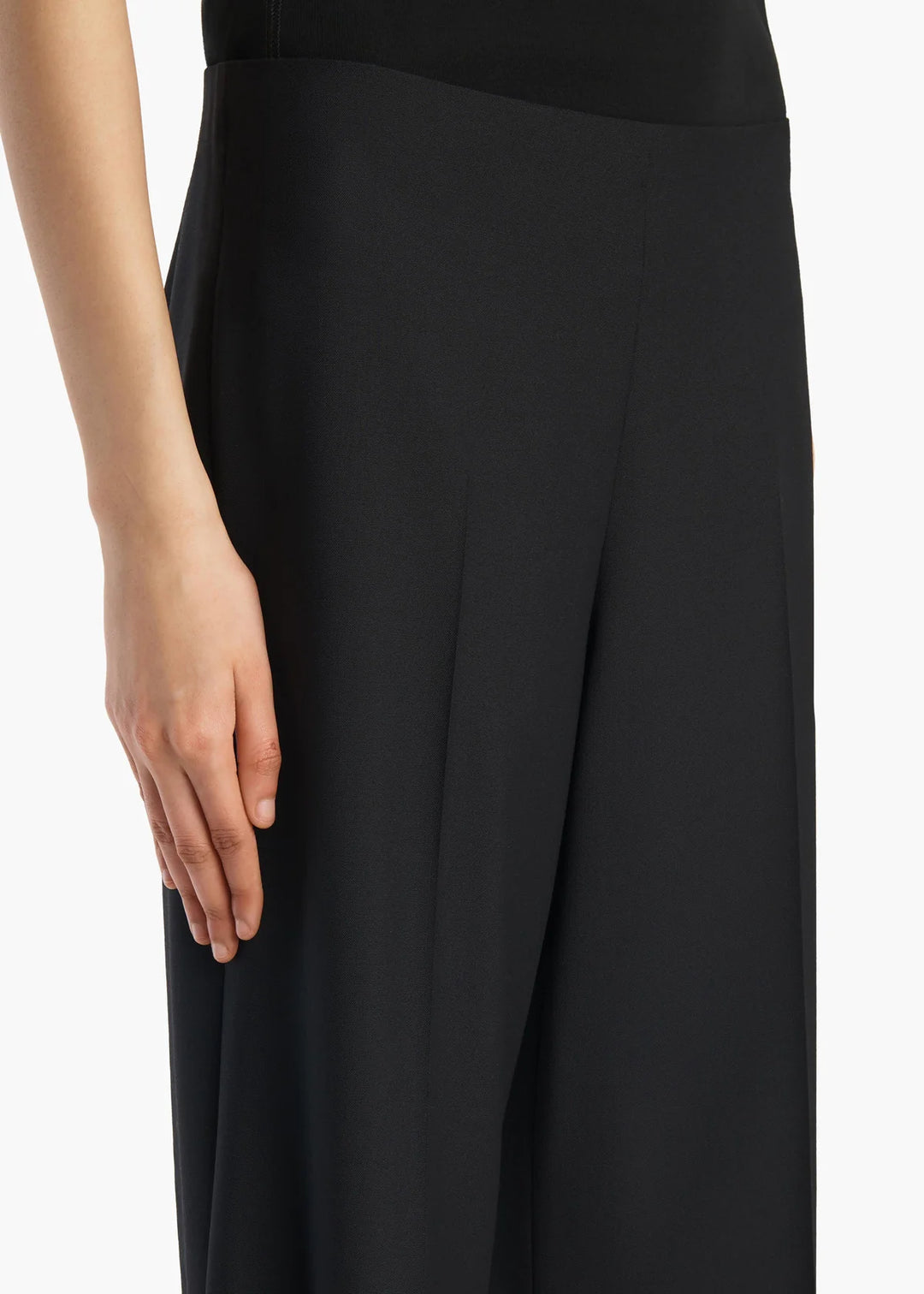 Black pants worn by a person on a white background
