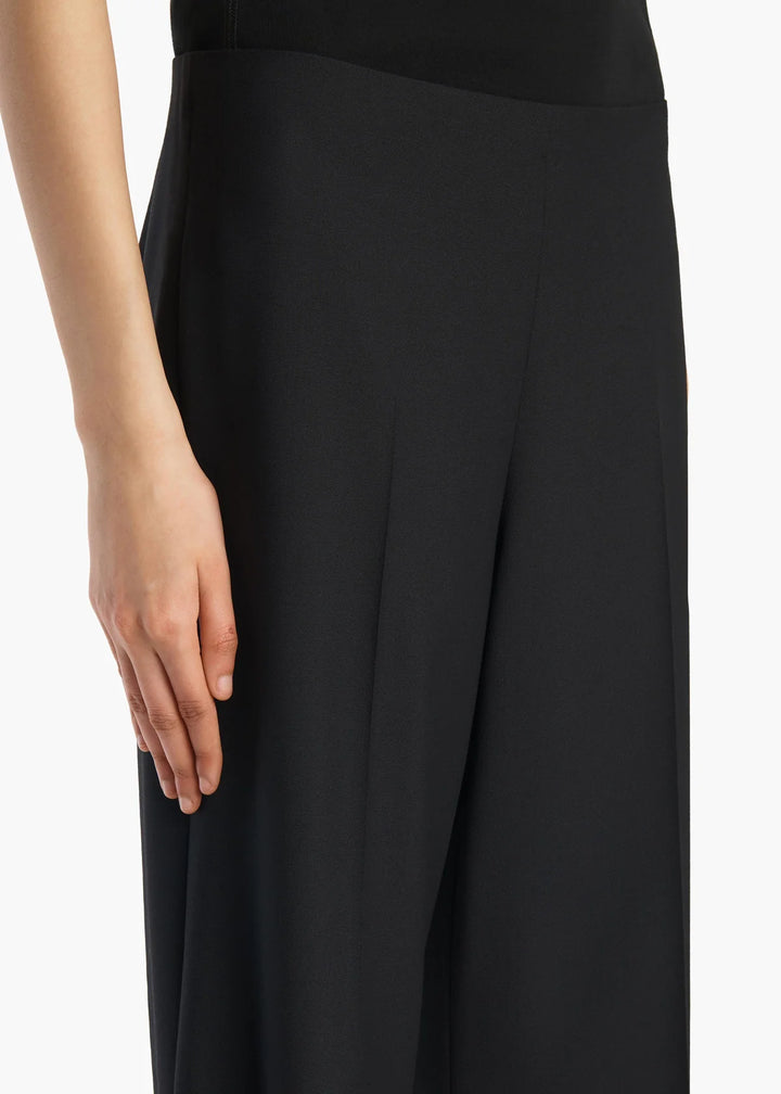 Black pants worn by a person on a white background