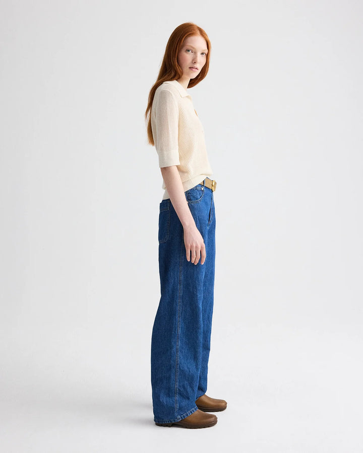 Woman wearing a white top and blue jeans on a white background