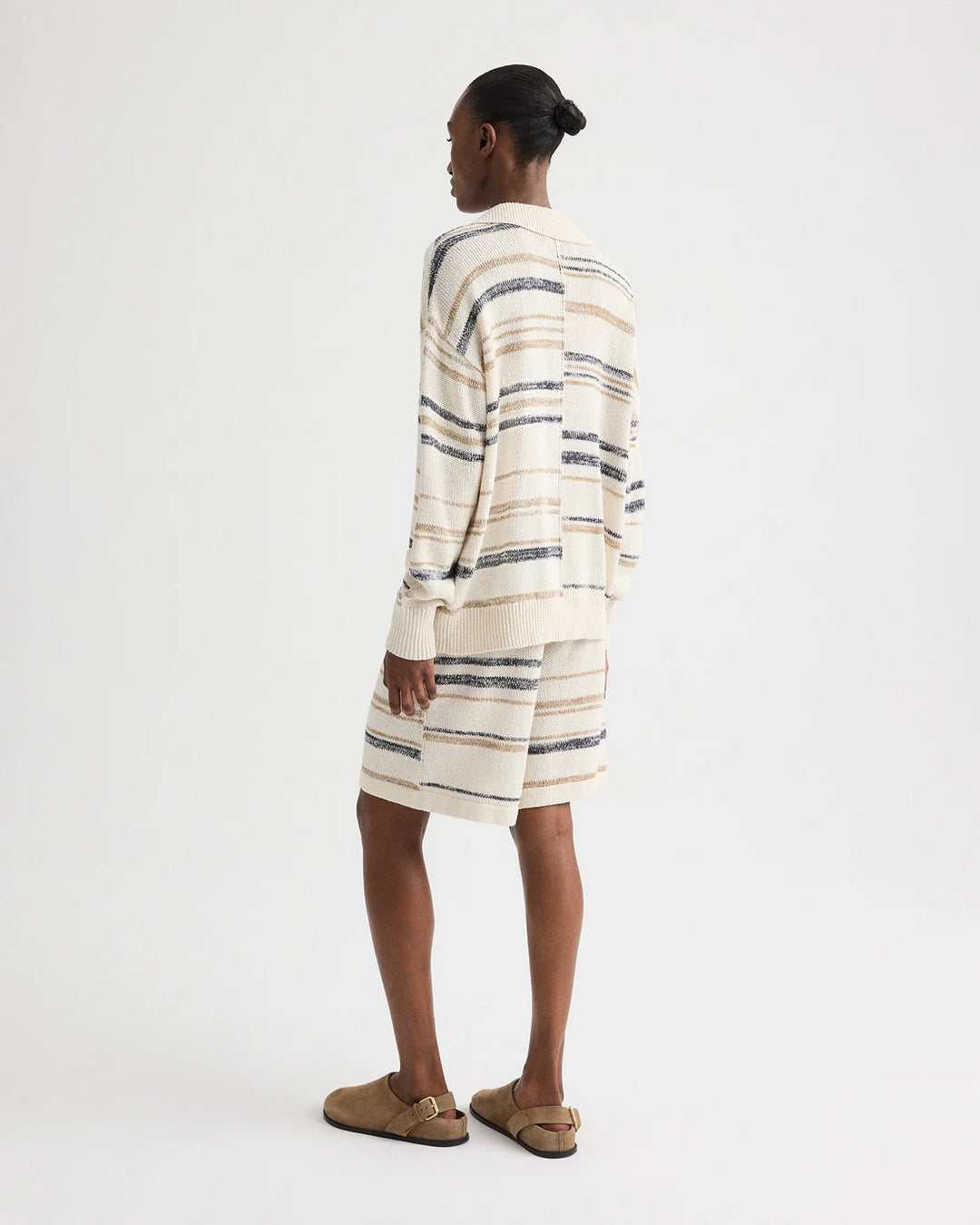 Person wearing a striped dress with a white background