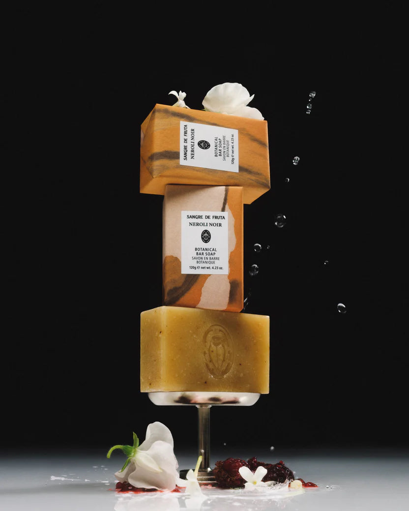 Two stacked soap bars with a label on a dark background