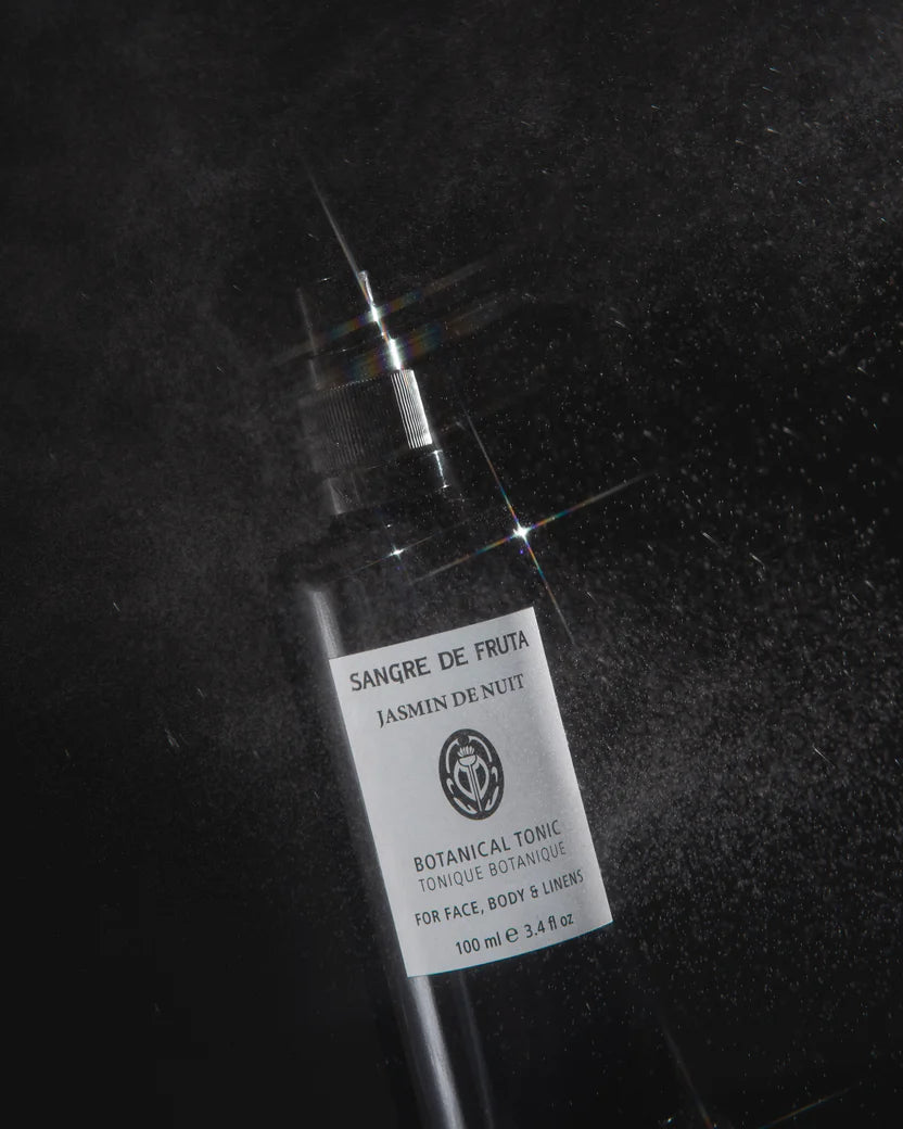 Bottle of 'Sangre de Fruta' botanical tonic on a dark background