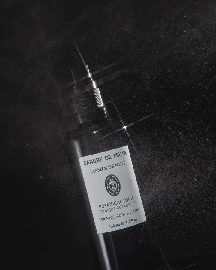 Bottle of 'Sangre de Fruta' botanical tonic on a dark background