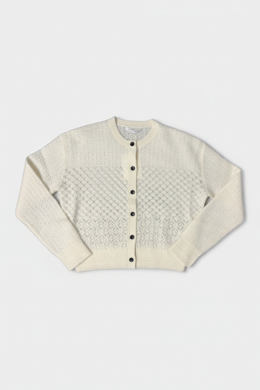 White textured cardigan with black buttons on a white background