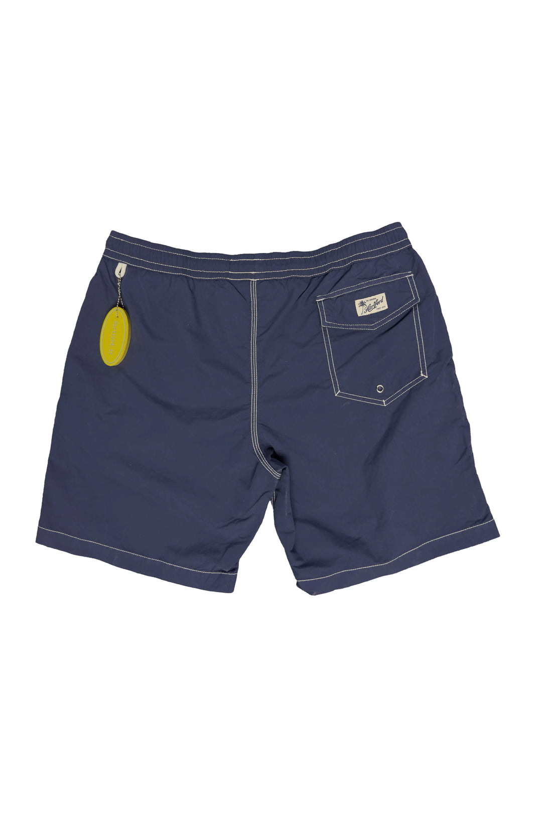 Navy blue shorts with a yellow tag on a white background