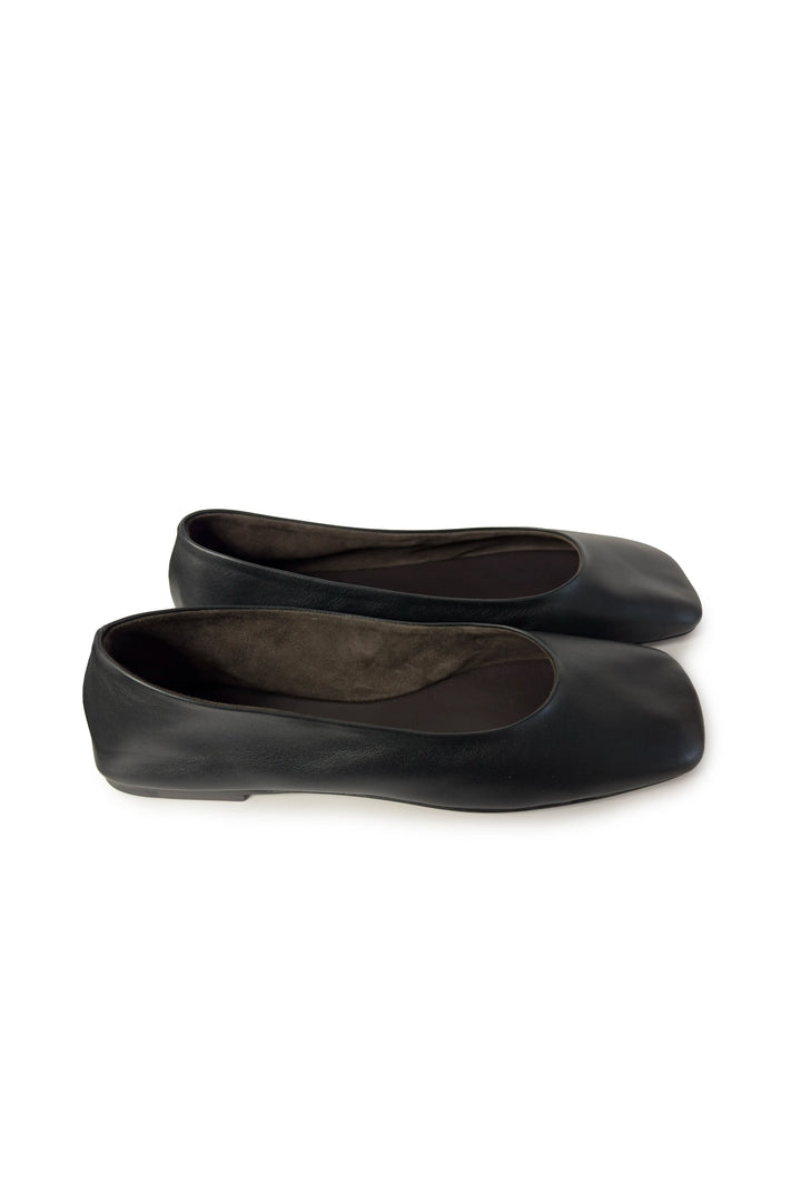 Pair of black ballet flats on a white background