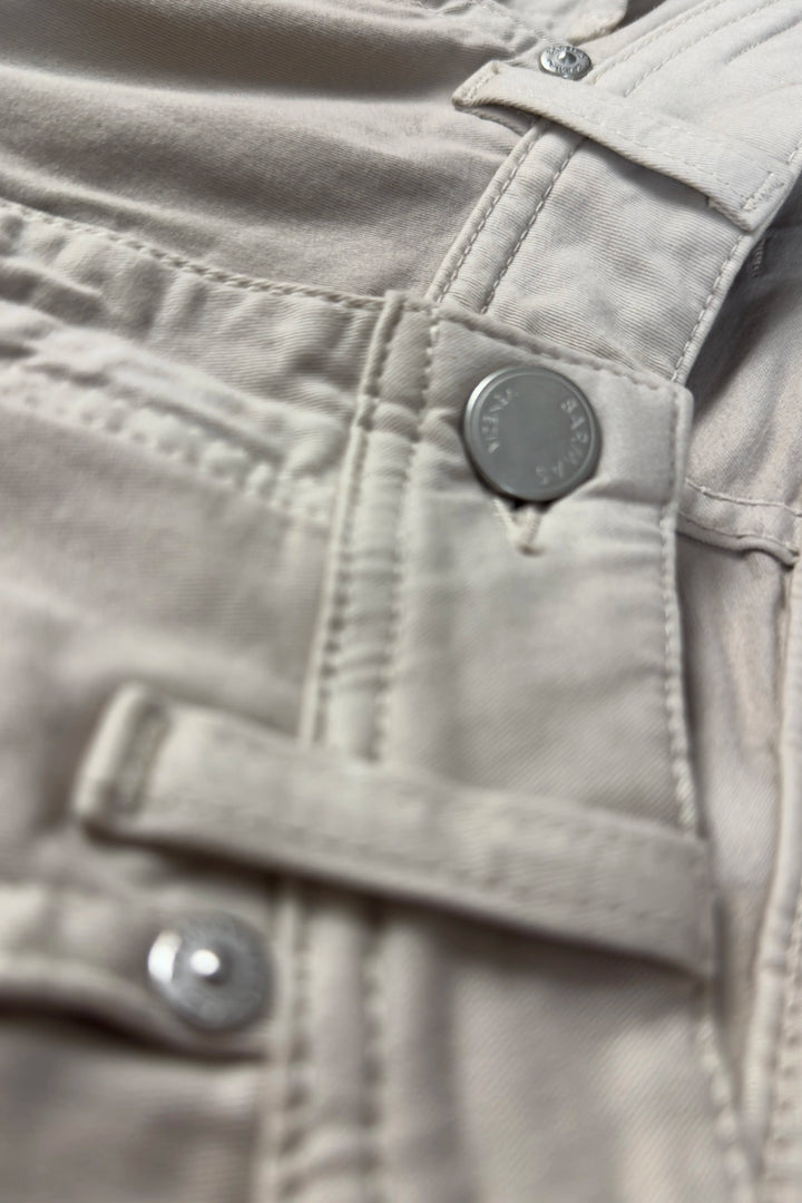Close-up of a beige jacket with buttons and a brand logo.