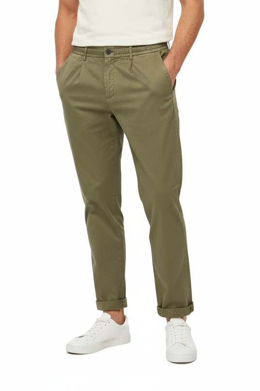 Person wearing olive green pants and white sneakers on a white background