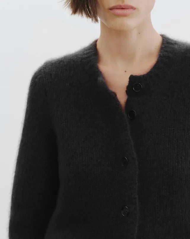Dark gray cardigan worn by a person on a white background