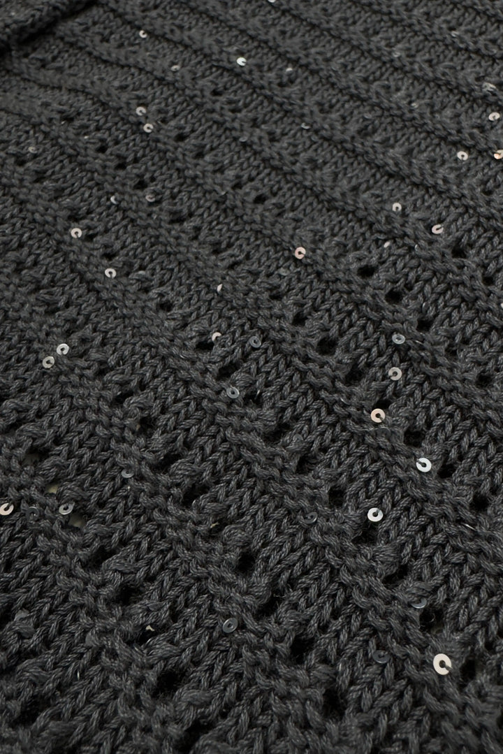 Close-up of a dark gray textured fabric with small sequins.