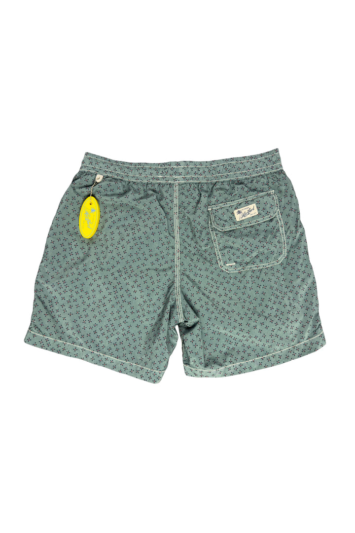 Green patterned shorts with a tag on a white background