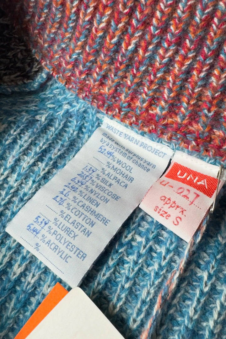Close-up of a sweater with fabric composition labels on a textured fabric background