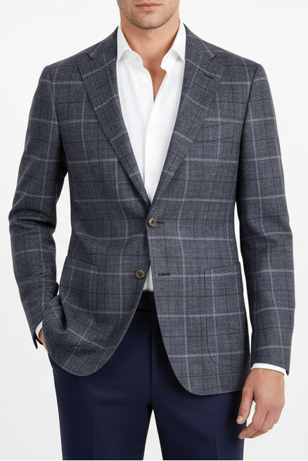 Man wearing a gray checkered blazer over a white shirt on a white background
