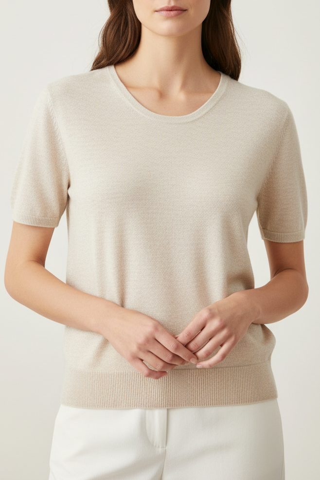 Woman wearing a beige sweater against a plain background