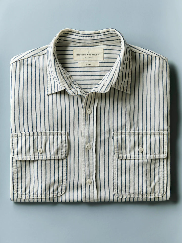 Folded striped shirt with a visible brand label on a light blue background