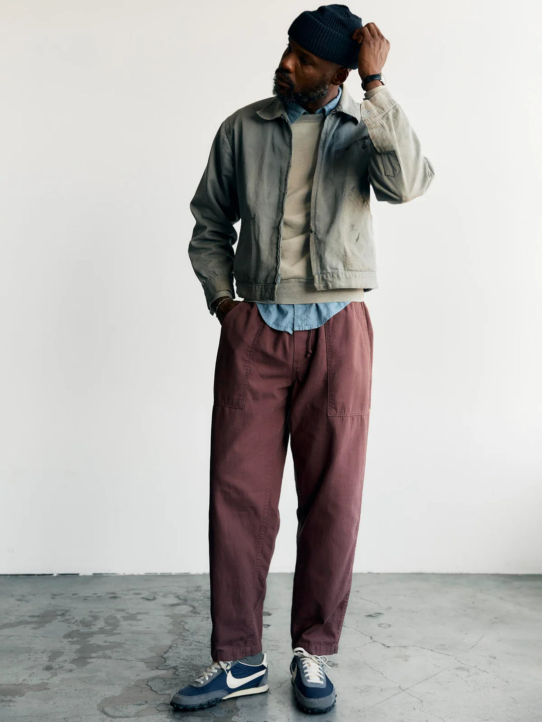 Man wearing a jacket, shirt, and pants with a white background