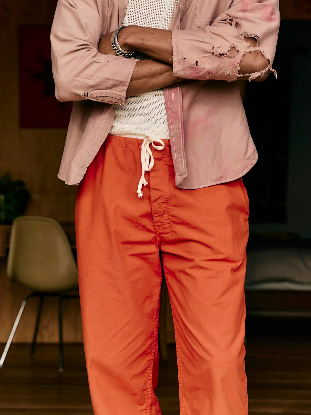 Person wearing a pink jacket and orange pants in an indoor setting