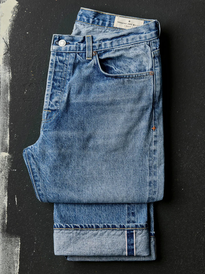 Folded blue jeans on a black background