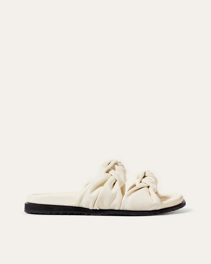 White sandal with knotted design on a white background