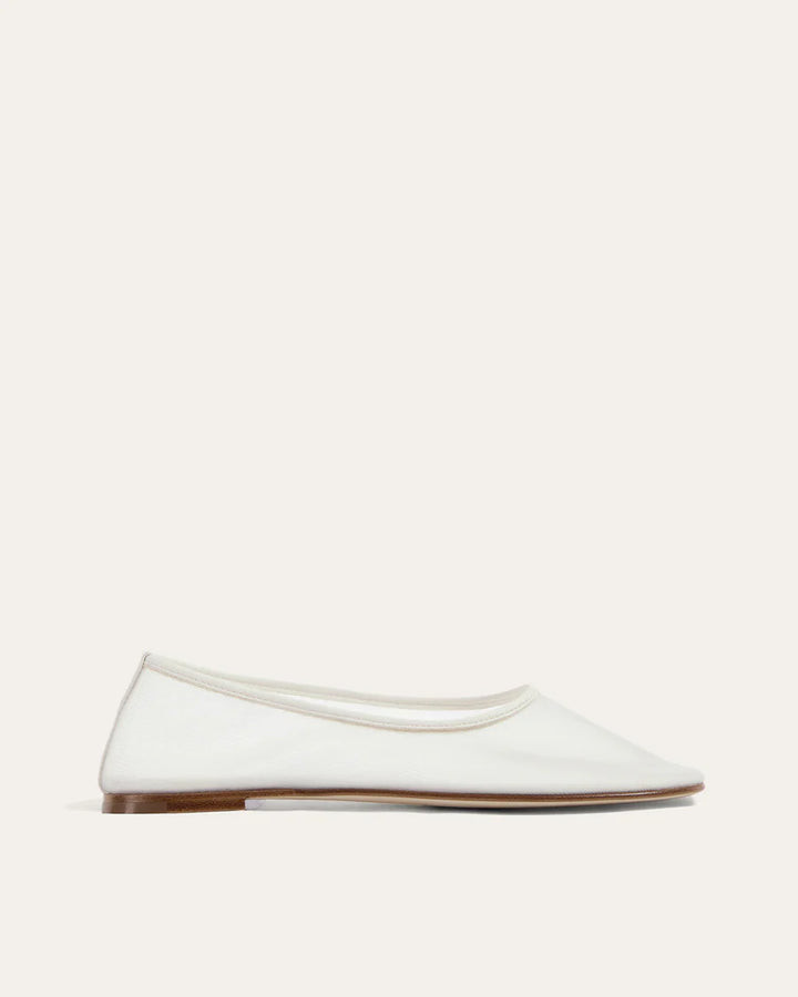 White flat shoe on a light beige background