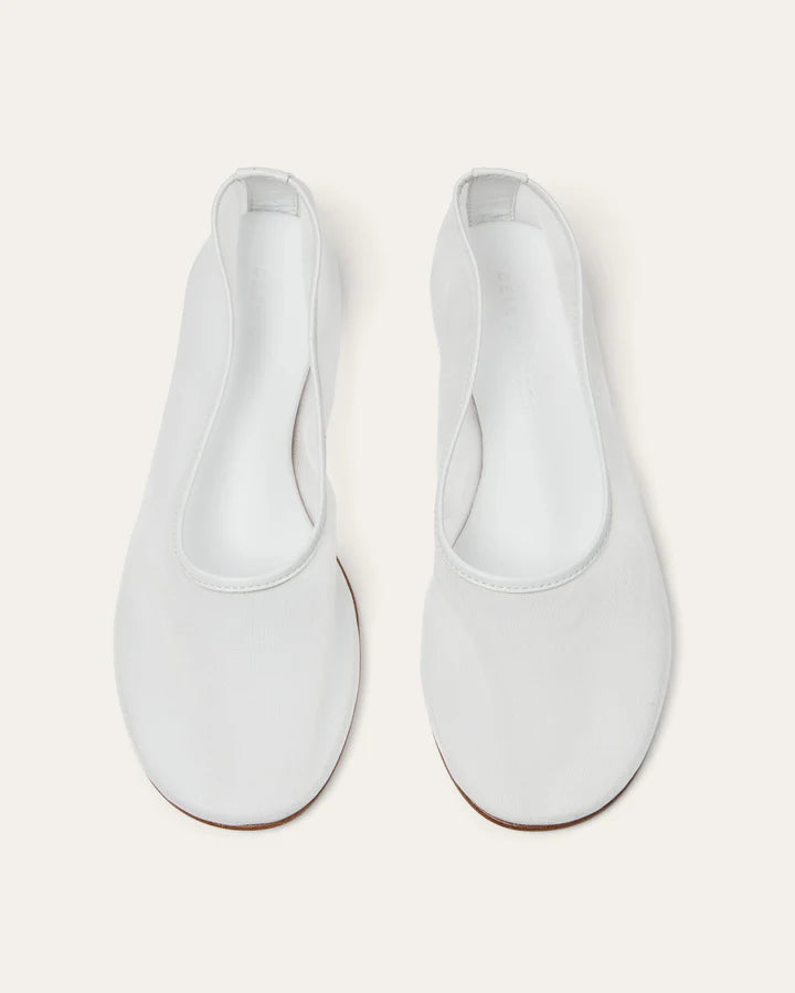 Pair of white flat shoes on a light gray background