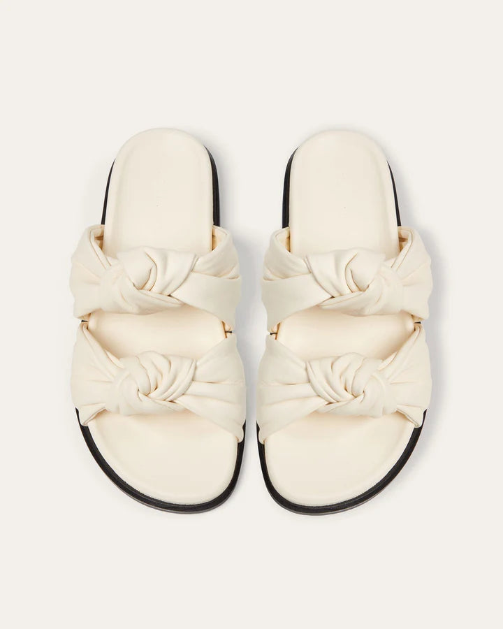 Pair of cream-colored sandals with braided design on a white background