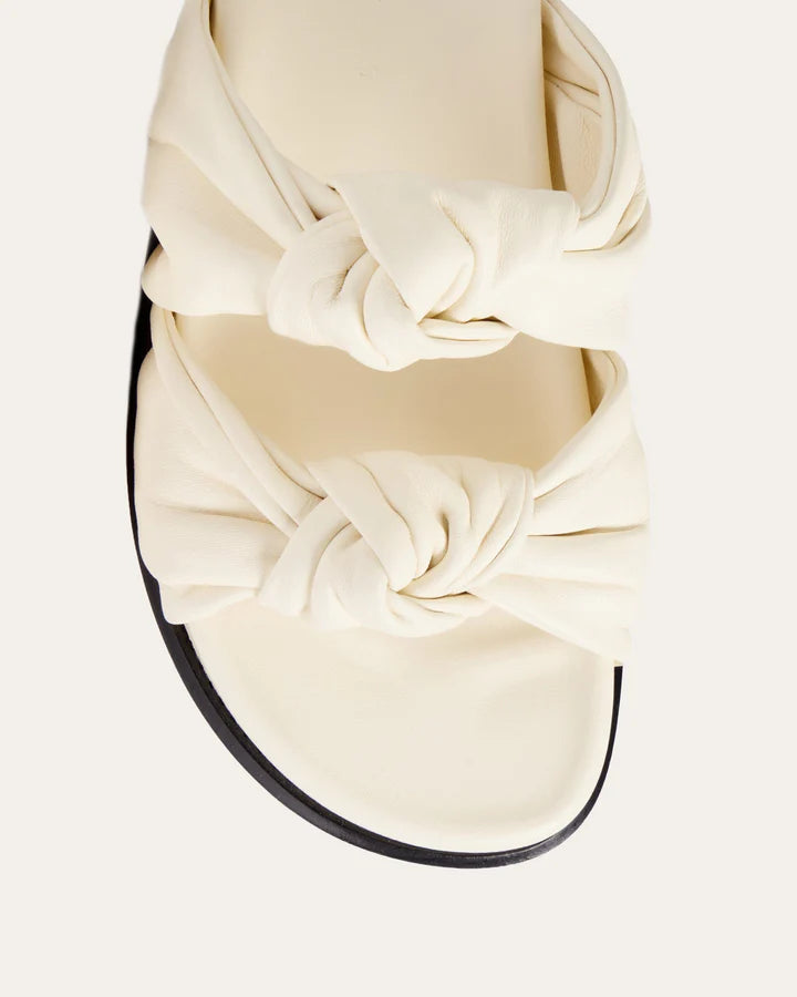 White sandal with a large bow on a light gray background